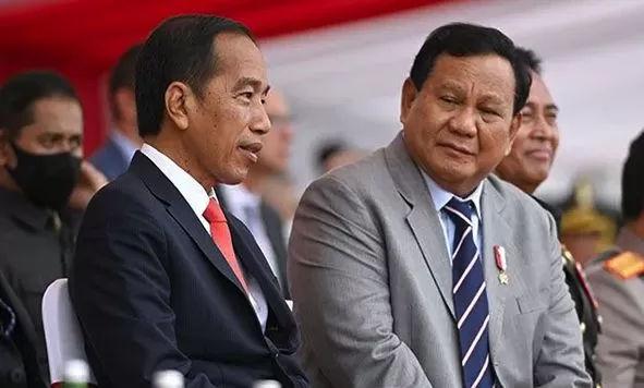 Gambar Presiden Jokowi dengan baju bewarna hitam dan Prabowo Subianto di sebelahnya.