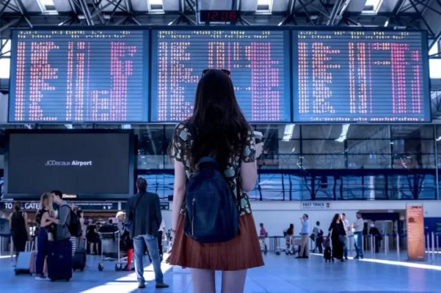 Potret seorang wanita yang berdiri di sebuah bandara.