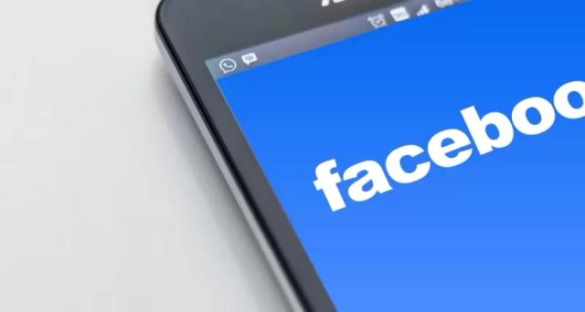 Sebuah smartphone meyala yang berisi tulisan Facebook dengan background berwarna biru, ilustrasi cara mengembalikan akun FB kena hack.