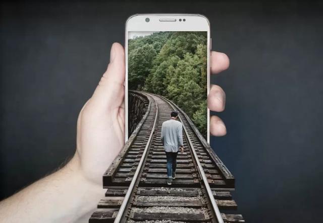 Gambar ilustrasi seseorang yang berjalan masuk ke sebuah smartphone bewarna putih.