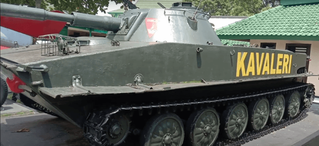 Gambar sebuah monumen tank berwarna hijau.