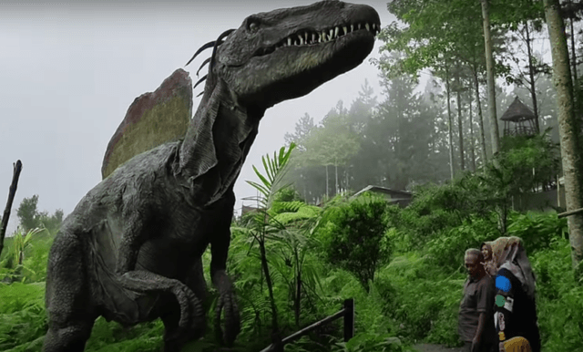 Gambar patung dinosaurus besar yang sedang dilihat oleh pengunjung wisata Purbalingga hits.