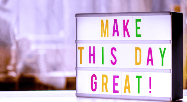 Gambar sebuah papan berisikan tulisan 'Make This Day Great!'