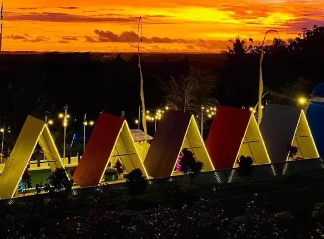 Gambar beberapa bangunan berbentuk kerucut dengan latar belakang sunset yang indah.