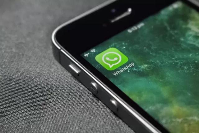 Gambar sebuah smartphone berisi aplikasi WhatsApp berwarna hijau.