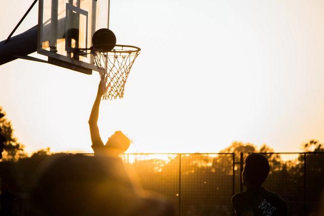 Gambar siluet dari seseorang yang sedang bermain basket, ilustrasi kata-kata pembangkit semangat untuk diet.