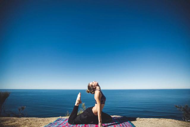 Gambar seorang wanita yang sedang melakukan gerakan yoga, ilustrasi olahraga membakar lemak di rumah yang efektif.