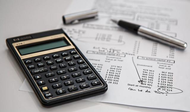 Gambar kalkulator dan kertas tagihan, foto ilustrasi cara hapus akun pinjol legal.