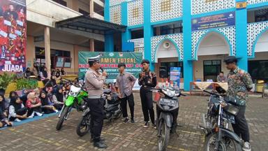 Personel Satlantas Polres Purbalingga sedang memeriksa sepeda motor milik pelajar saat kegiatan sosialisasi tertib lalu lintas di SMA Muhammadiyah 1 Purbalingga, Kamis (12/12/2024). (Foto: Humas Polres Purbalingga).