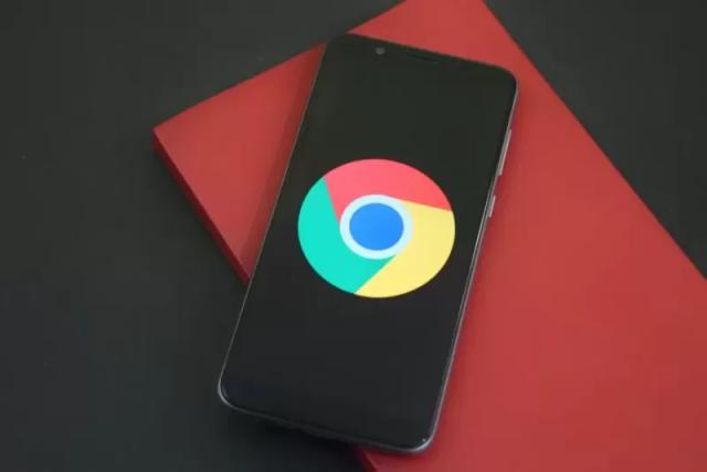 Gambar logo Google Chrome yang berada di dalam sebuah smartphone berwarna hitam.