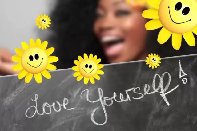 Gambar seseorang yang tersenyum dan menampilkan papan bertuliskan 'Love Yourself!'
