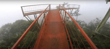 Gambar sebuah jembatan berwarna merah yang ada di area wisata Purbalingga.