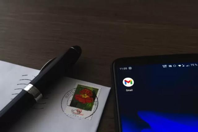 Gambar sebuah pena, surat dan smartphone yang berisi aplikasi Gmail.