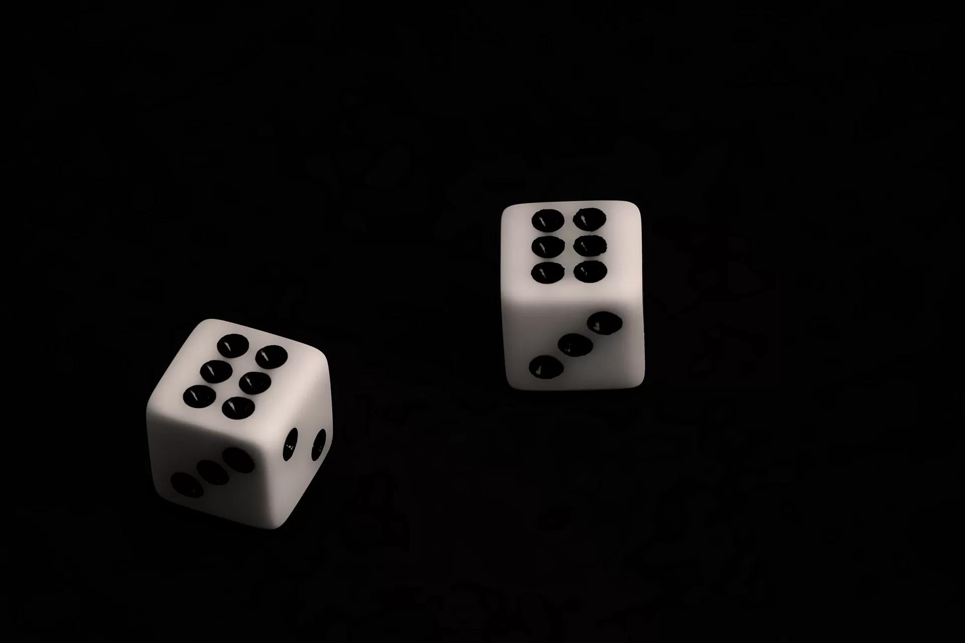 Gambar dua buah dadu putih dengan background warna hitam.