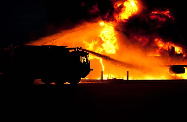 Gambar mobil pemadam kebakaran yang sedang memadamkan api.