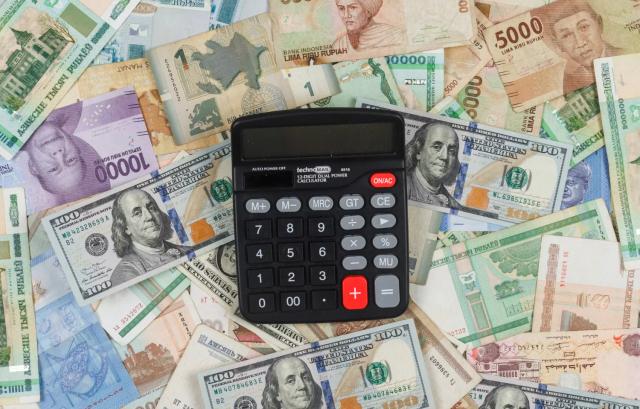 Gambar uang dan kalkulator, ilustrasi cara mengatasi teror pinjaman online.