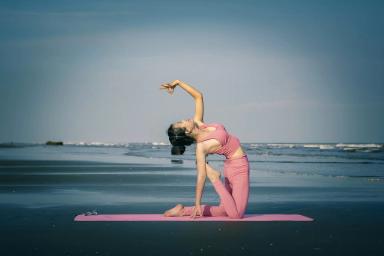 Potret seorang wanita yang sedang melakukan gerakan Yoga.